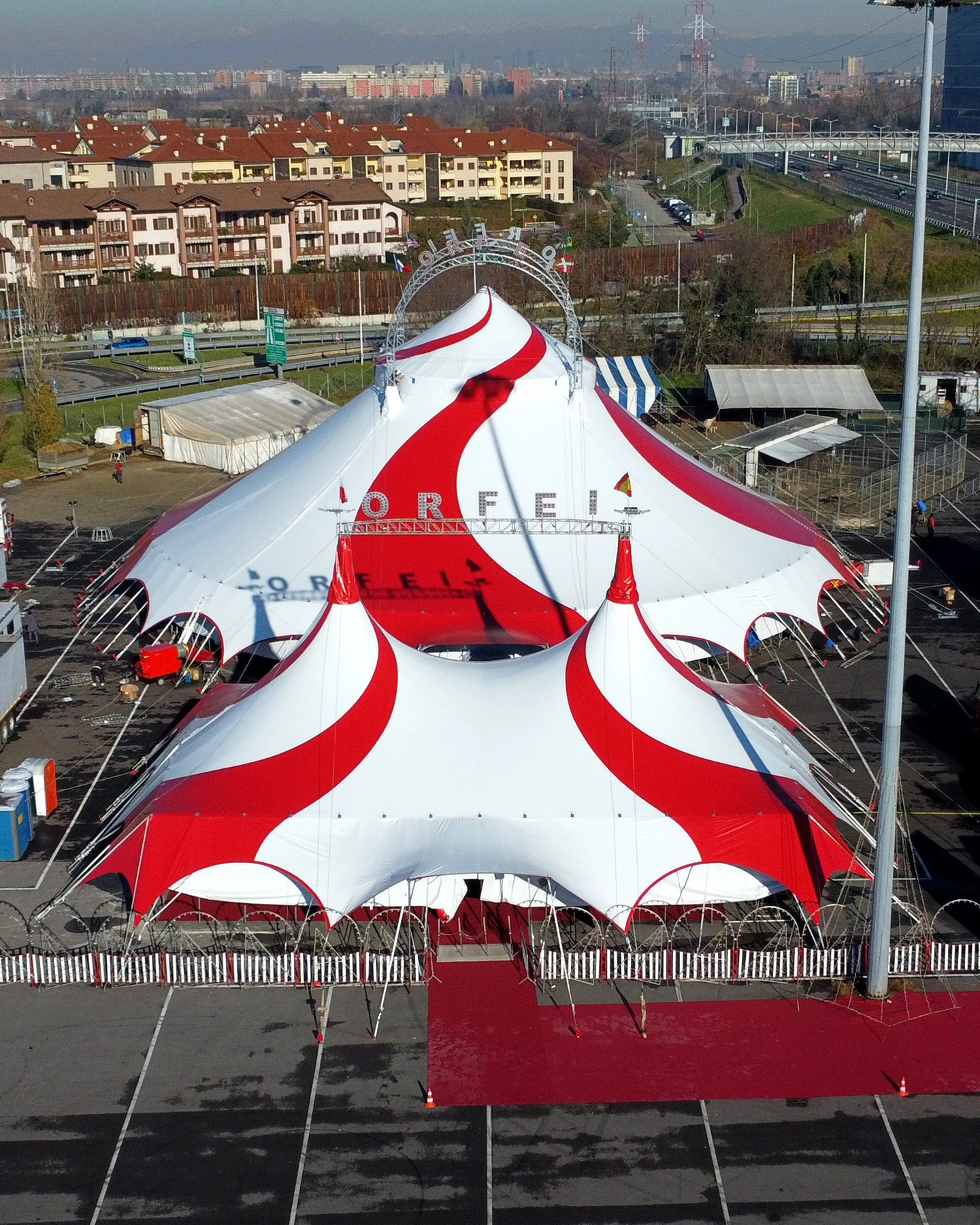 Vista aerea frontale del grande tendone bianco e rosso del Circo Greca Orfei